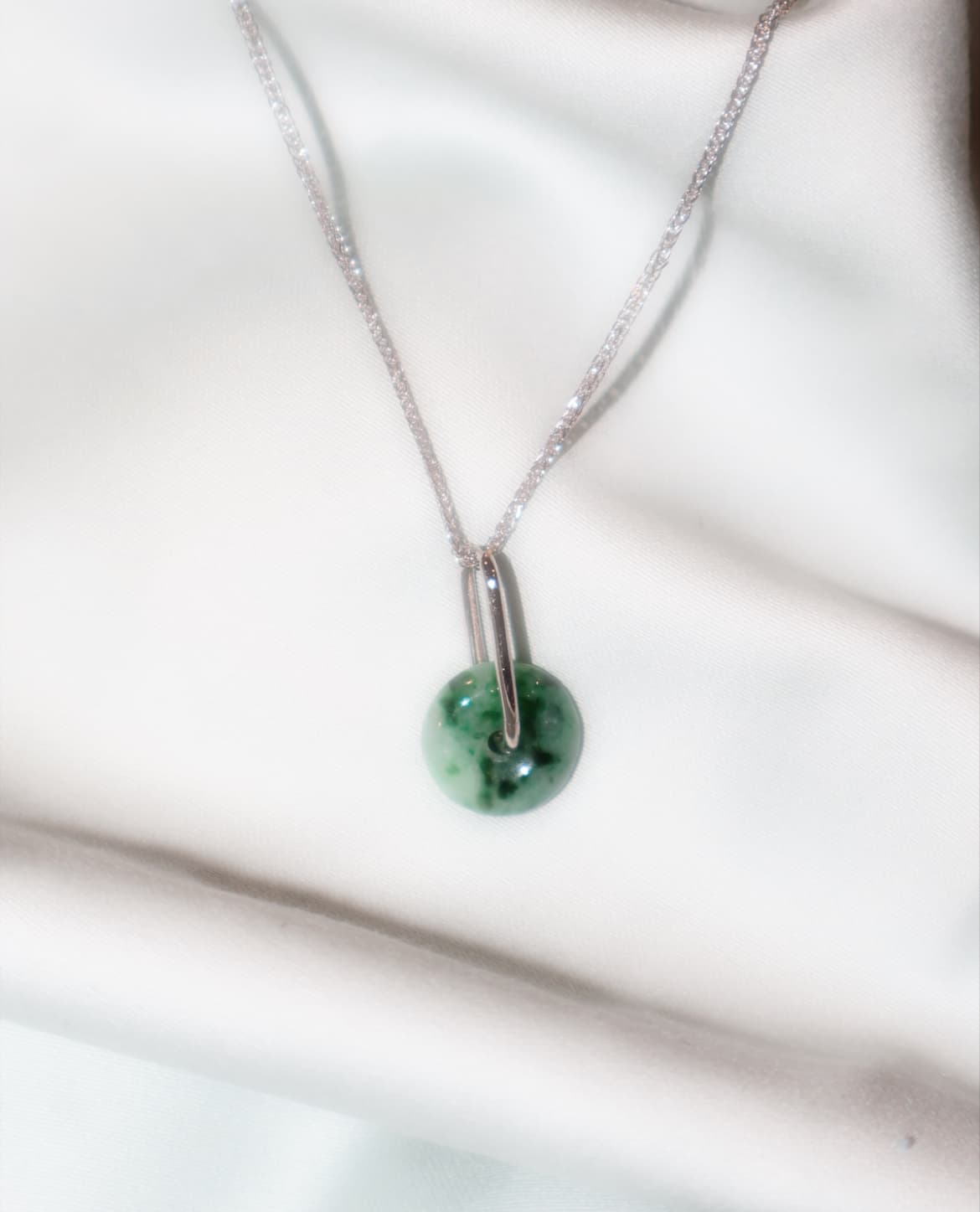 Close-up of a jade donut pendant with a bail